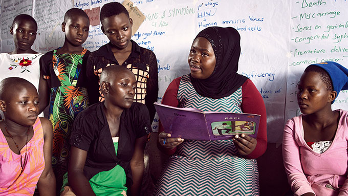 Nubu Nubrah reads to girls at the Kikaaya girls’ club. Stephan Gladieu/World Bank