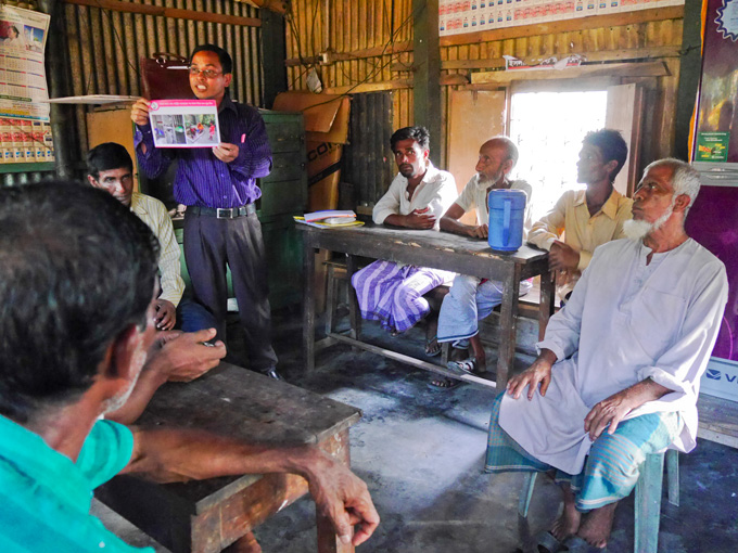 Horan Chandra, BRAC field organiser engages the men in discussion at a tea stall in Kaliganj
