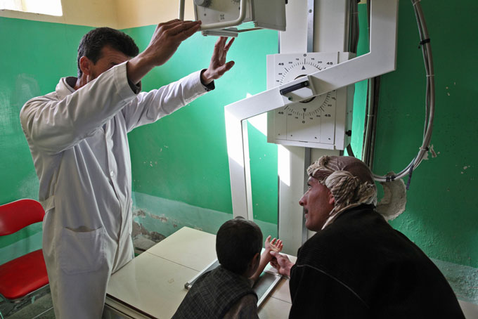 Doctor sets up the x-ray machine before examining a child’s arm.